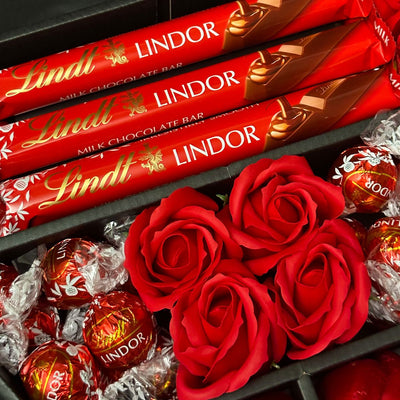 Close up of Lindt Lindor Treat bars, roses and chocolate truffles inside exclusive HamperWell stunning bouquet packaging
