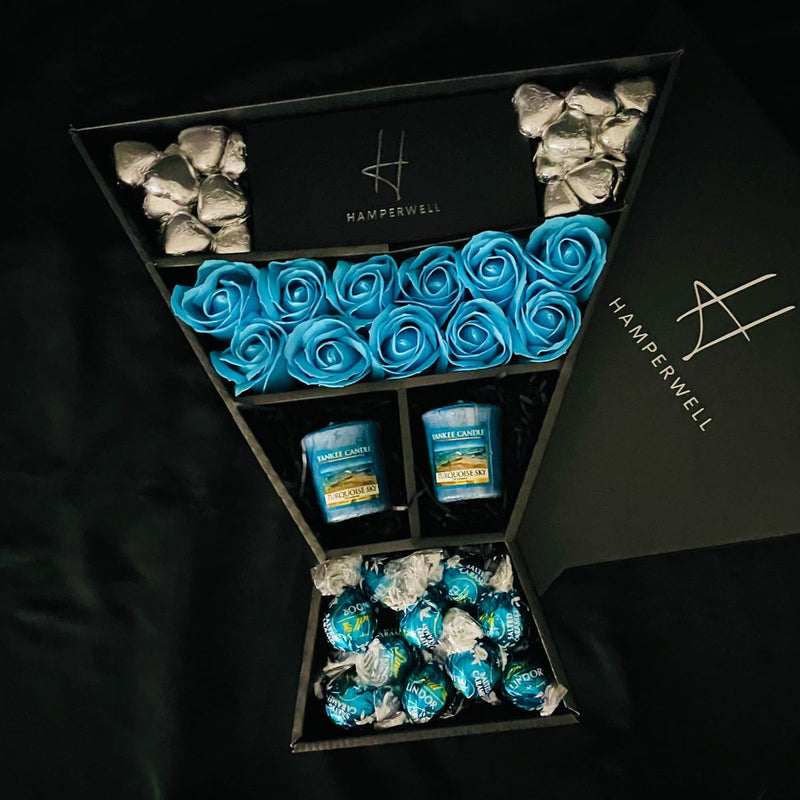 Lindt Lindor & Yankee Candle Signature Chocolate Bouquet With Blue Roses on angle handmade chocolate box lid over truffles