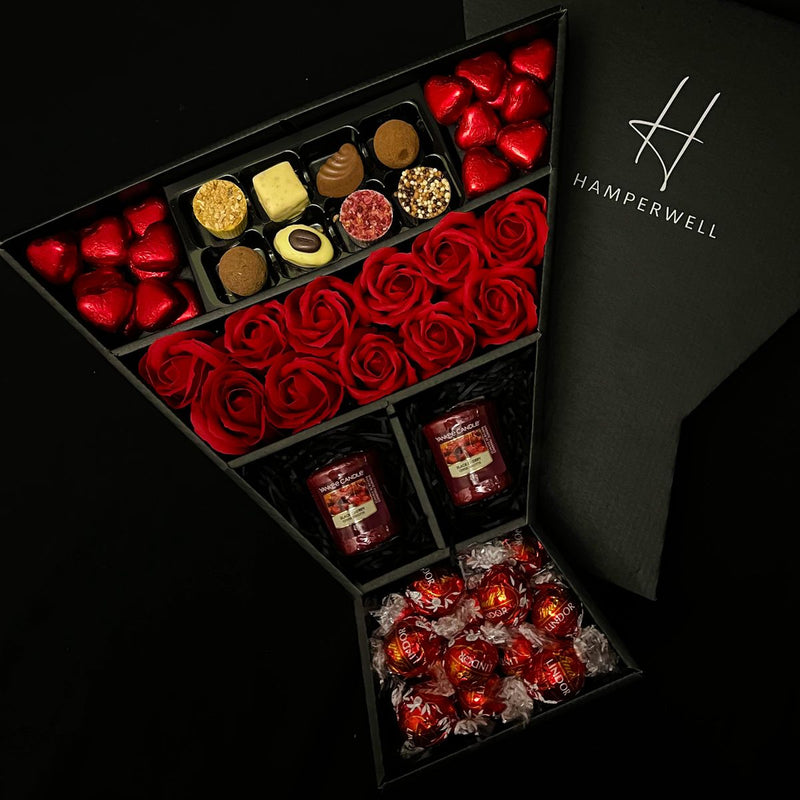 HamperWell Lindt Lindor & Yankee Candle Chocolate Bouquet With Red Roses displayed with HamperWell logo on box lid behind 